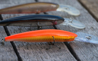 colorful fish baits are on a wooden background