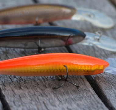 colorful fish baits are on a wooden background