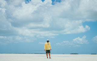 walking on a beach with a fishing pole