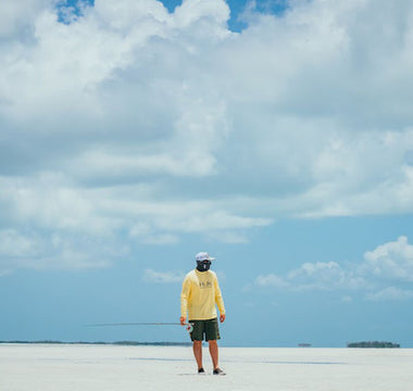 walking on a beach with a fishing pole